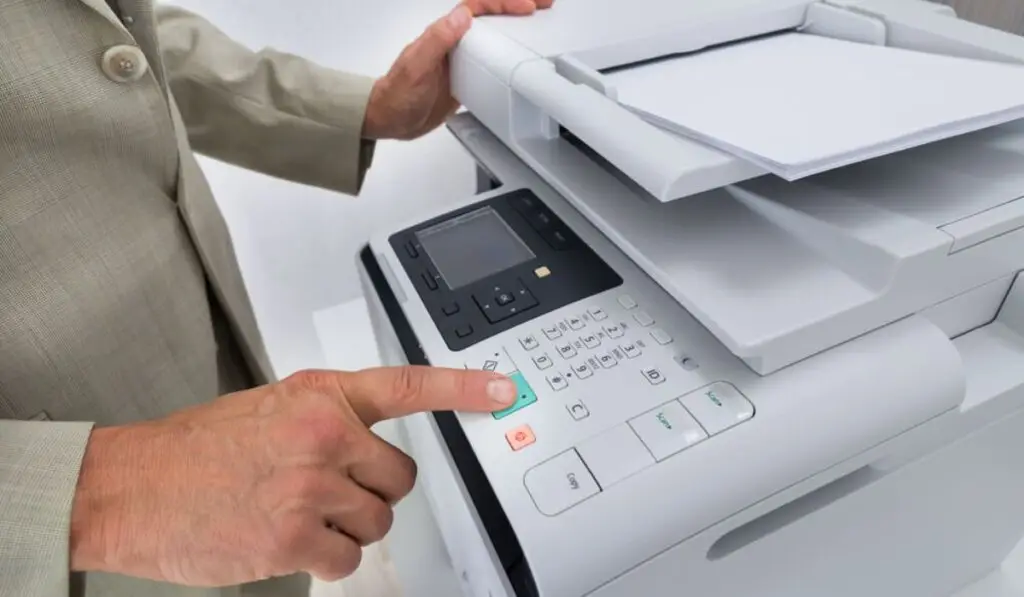 man pressing buttons on a printer